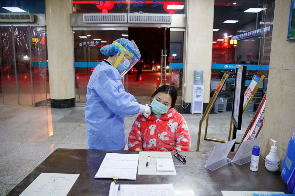PHOTO: A nurse takes the temperature of a woman in the reception area of the First People's Hospital in Yueyang, Hunan Province, China, Jan. 28, 2020.