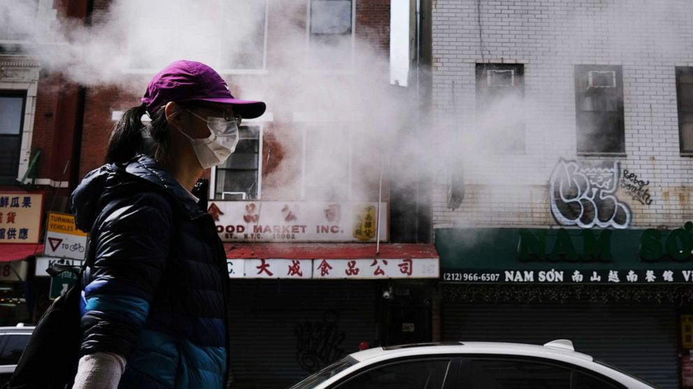 PHOTO: People walk down a street in Chinatown  as the coronavirus keeps financial markets and businesses mostly closed, April 21, 2020, in New York.