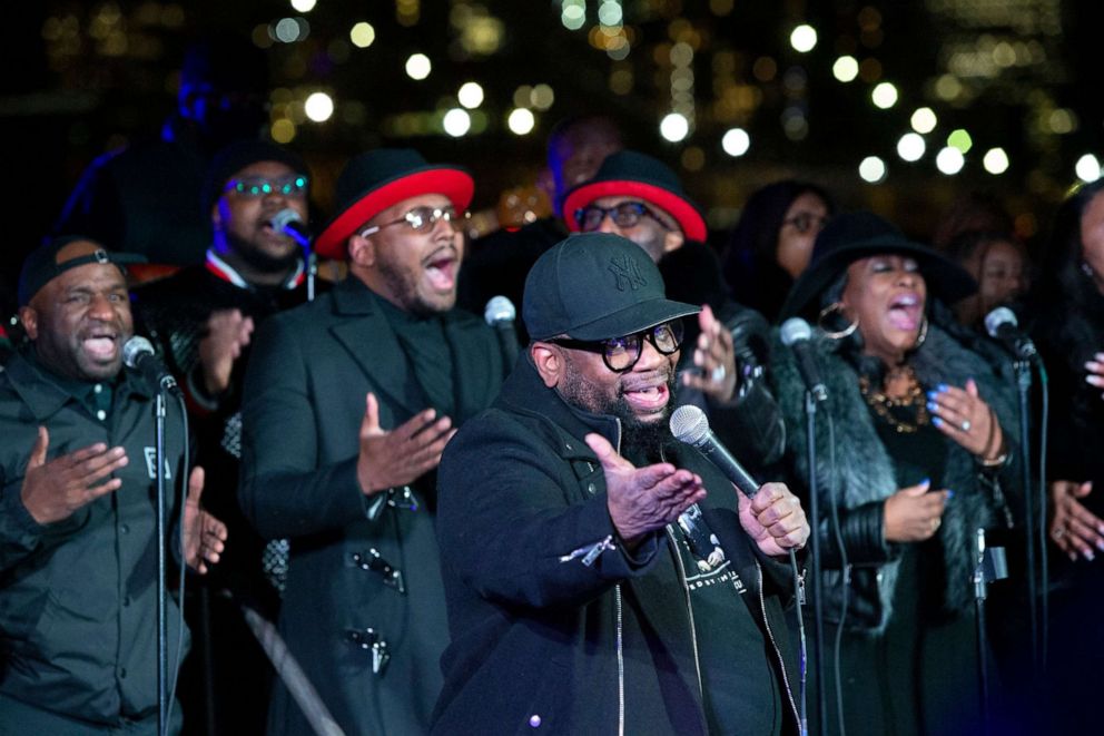 PHOTO: Bishop Hezekiah Walker and the Love Fellowship choir perform as images of COVID-19 victims are projected over the Brooklyn bridge as the city commemorates a COVID-19 "Day of Remembrance" in Brooklyn, New York, on March 14, 2021.