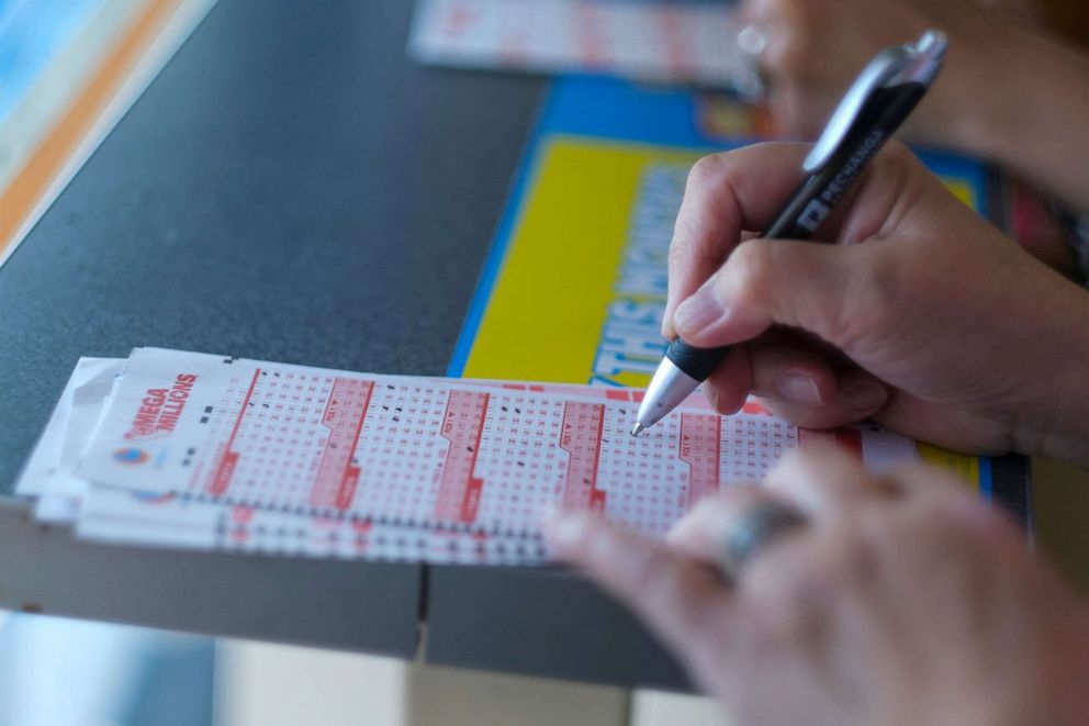 PHOTO: A woman checks off the numbers chosen for her Mega Millions lottery tickets at a 7-Eleven convenience store in Chino Hills, California, on July 28, 2022.