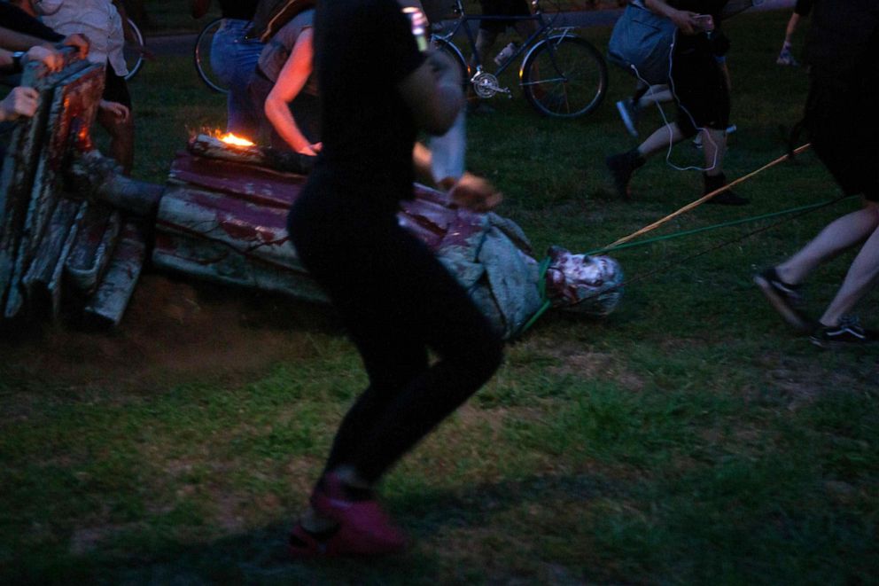 PHOTO: Protesters drag a statue of Christopher Columbus to a nearby pond after pulling it down in Byrd Park in Richmond, Virginia, on June 9, 2020.