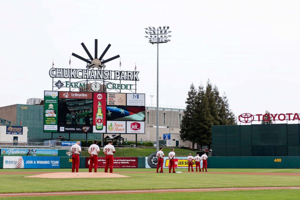 PHOTO: The Fresno Grizzlies stand in the field during the National Anthem before a game against the Reno Aces at Chukchansi Park, April 8, 2019, in Fresno, California.