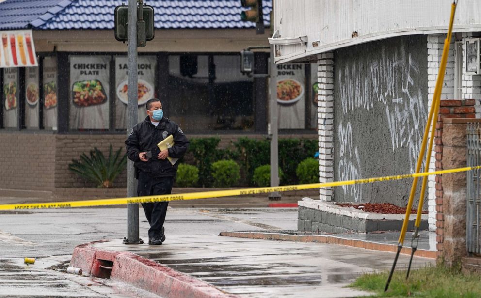 PHOTO: El Monte Police Chief David Reynoso, left, takes pictures of graffiti on the side wall of the First Works Baptist Church, after an explosion in El Monte, Calif., Saturday, Jan. 23, 2021.