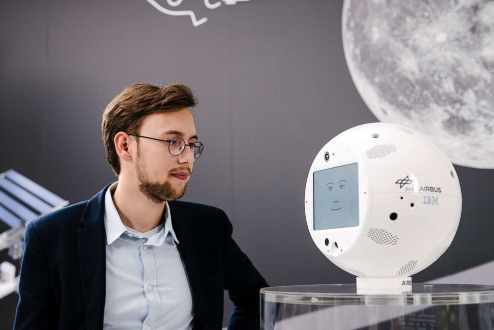 PHOTO: Matthias Biniok, IBM AI project lead of CIMON, speaks with CIMON, a mobile astronaut robot which is able to listen, understand and respond in natural language with humans.