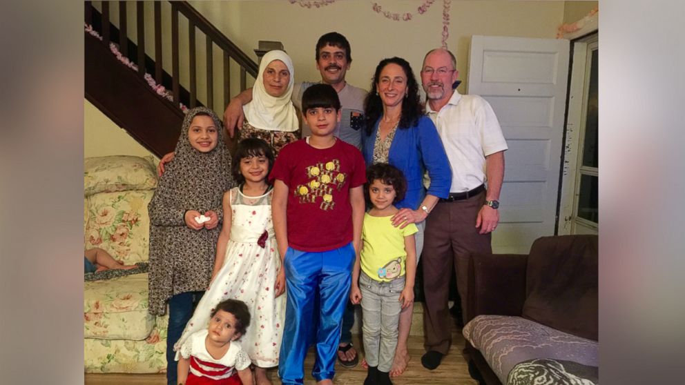 Clea and Tom Angell take a picture with Abdulaziz and his family from Syria. Tom Angell said the language barrier had not stopped the two families from building a strong relationship.