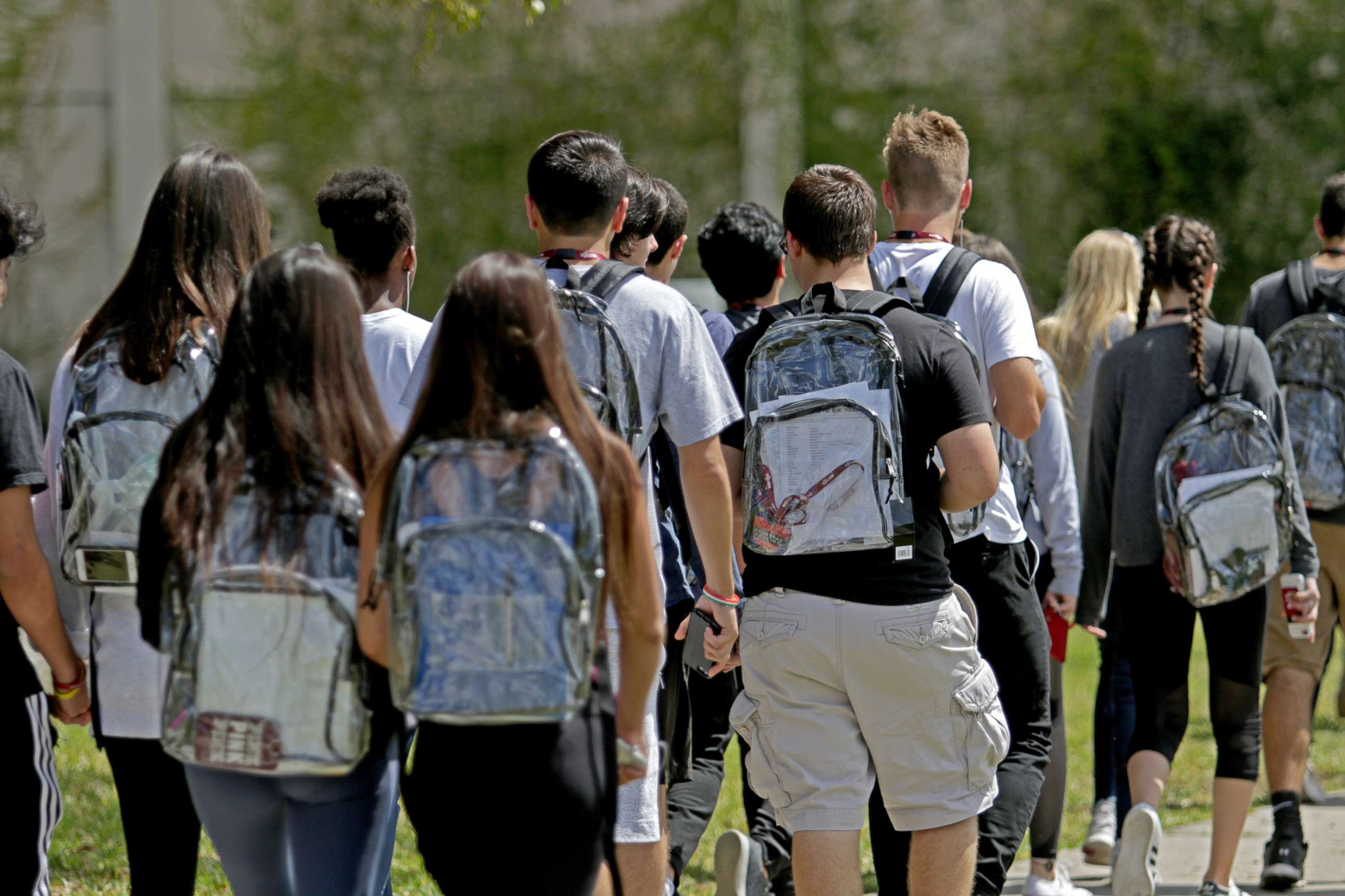 PHOTO: Students walk to school at Marjory Stoneman Douglas wearing clear backpacks, as part of their schools new security measures after the Feb. 14, 2018 shooting that killed 17 people, in Parkland, Fla., April 2, 2018.