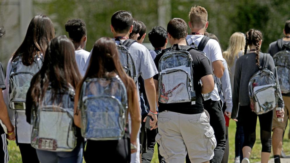 PHOTO: Students walk to school at Marjory Stoneman Douglas wearing clear backpacks, as part of their schools new security measures after the Feb. 14, 2018 shooting that killed 17 people, in Parkland, Fla., April 2, 2018.