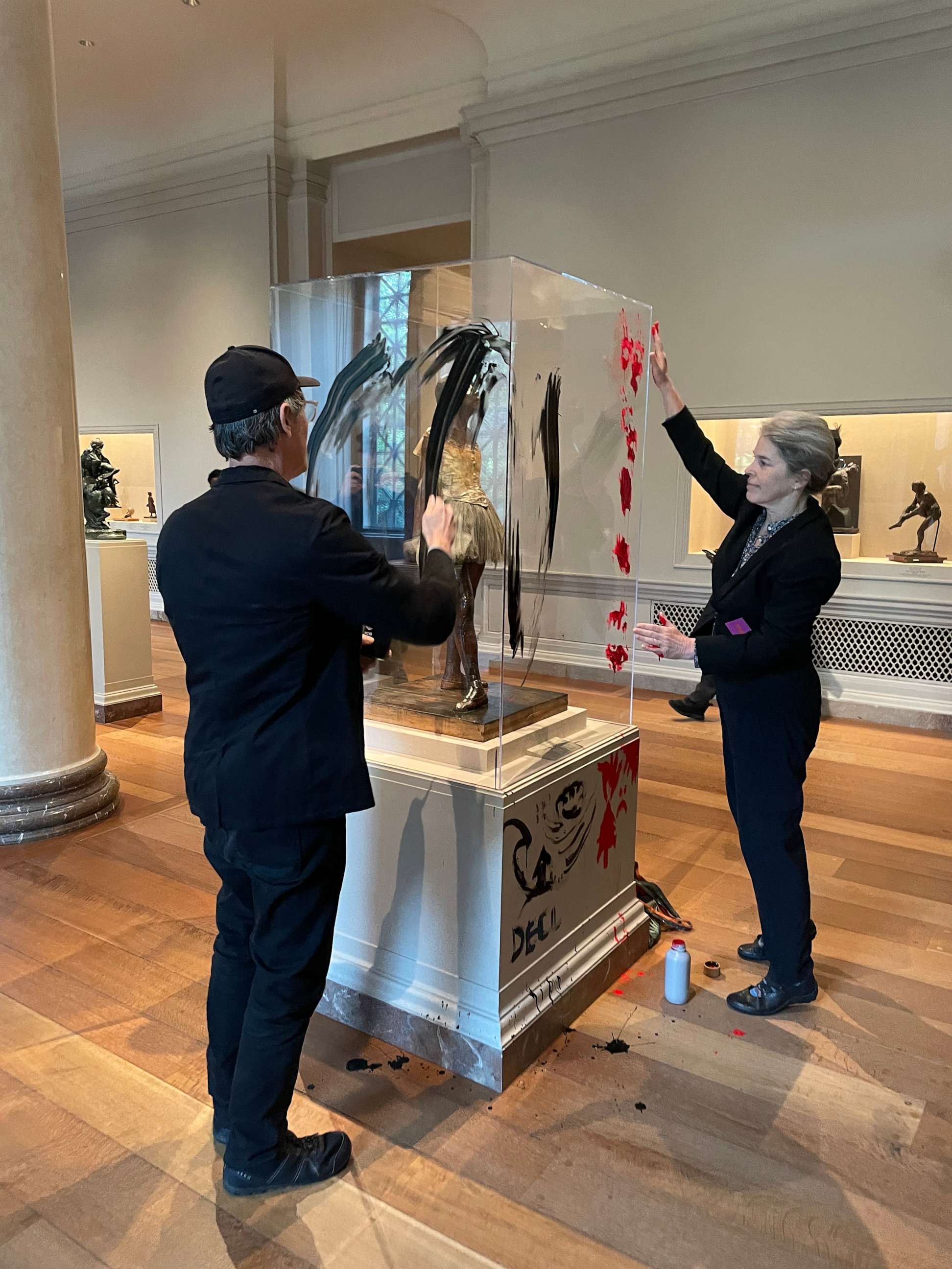 PHOTO: Climate protesters smear paint on the case that houses Edgar Degas's Little Dancer Aged Fourteen at the National Gallery of Art in Washington, April 27, 2023.