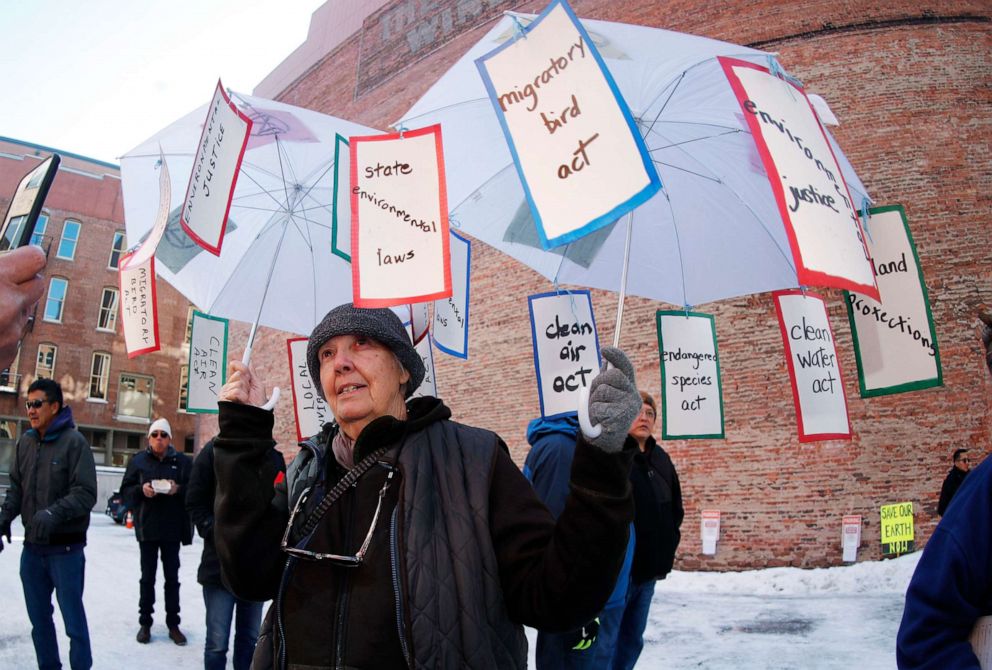 PHOTO: In this Feb. 11, 2020, file photo taken in Denver, Jay Bender holds up an umbrella adorned with programs that would be affected at a rally to voice opposition to efforts by the Trump administration to weaken the National Environmental Policy Act.