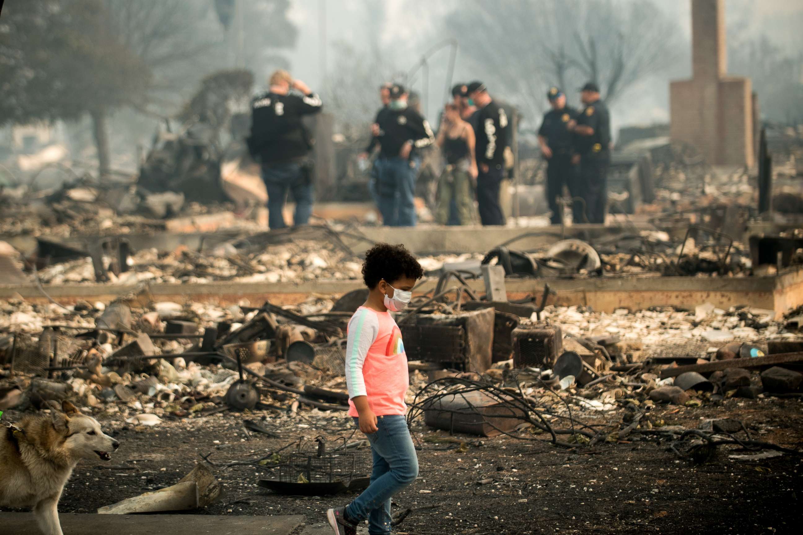 PHOTO: A child walks by as police officers search for signs of a Coffey Park resident who was missing since the Tubbs fire roared through the neighborhood, Oct. 10, 2017 in Santa Rosa, Calif.