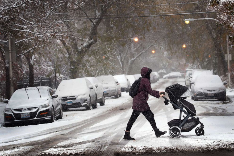 PHOTO: A resident walks through snow with her child in the Wicker Park neighborhood, Nov. 11, 2019, in Chicago, Illinois.