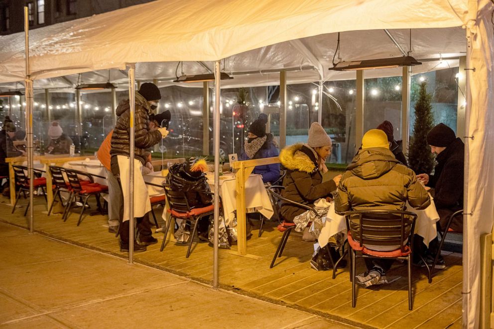PHOTO: Customers wearing winter jackets sit with emergency thermal blankets while dining outdoors at Cafe Luxembourg as temperatures drop below freezing in New York on Jan. 28, 2021.