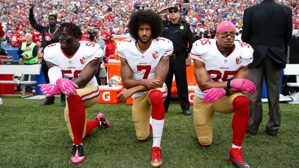 Eli Harold #58, Colin Kaepernick #7, center, and Eric Reid #35 of the San Francisco 49ers kneel in protest on the sideline, during the anthem, prior to the game against the Buffalo Bills at New Era Field, Oct. 16, 2016, in Orchard Park, New York.