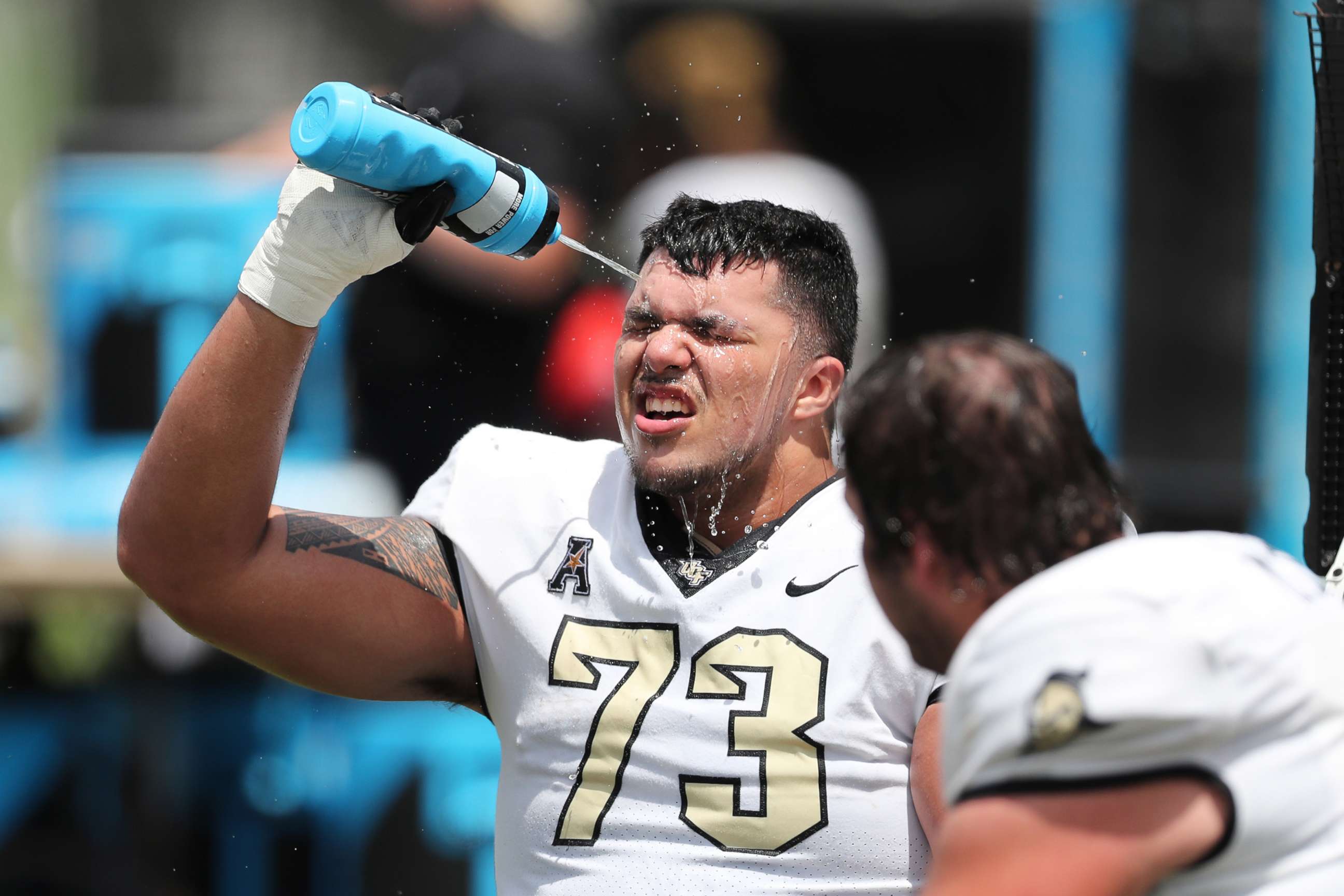 PHOTO: An offensive lineman of the UCF Knights sprays himself to cool off from the heat during the UCF Spring Game at the Bounce House on April 16, 2022 in Orlando, Fla. 