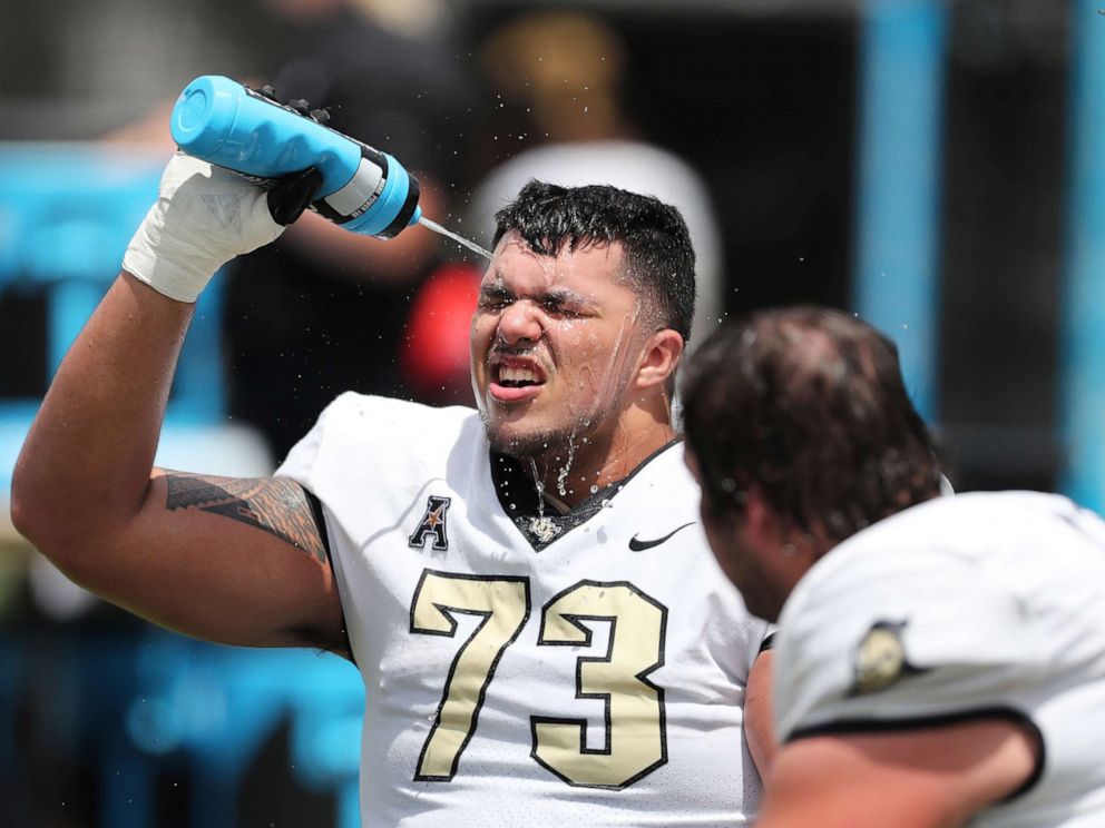 PHOTO: An offensive lineman of the UCF Knights sprays himself to cool off from the heat during the UCF Spring Game at the Bounce House on April 16, 2022 in Orlando, Fla. 