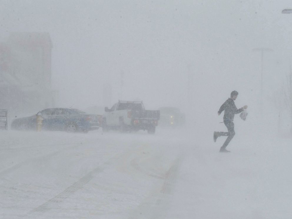 PHOTO: Clutching a bag of groceries a man sprints to his car as he leaves the Sprouts grocery store on North Gate Blvd. in Colorado Springs, Colo.