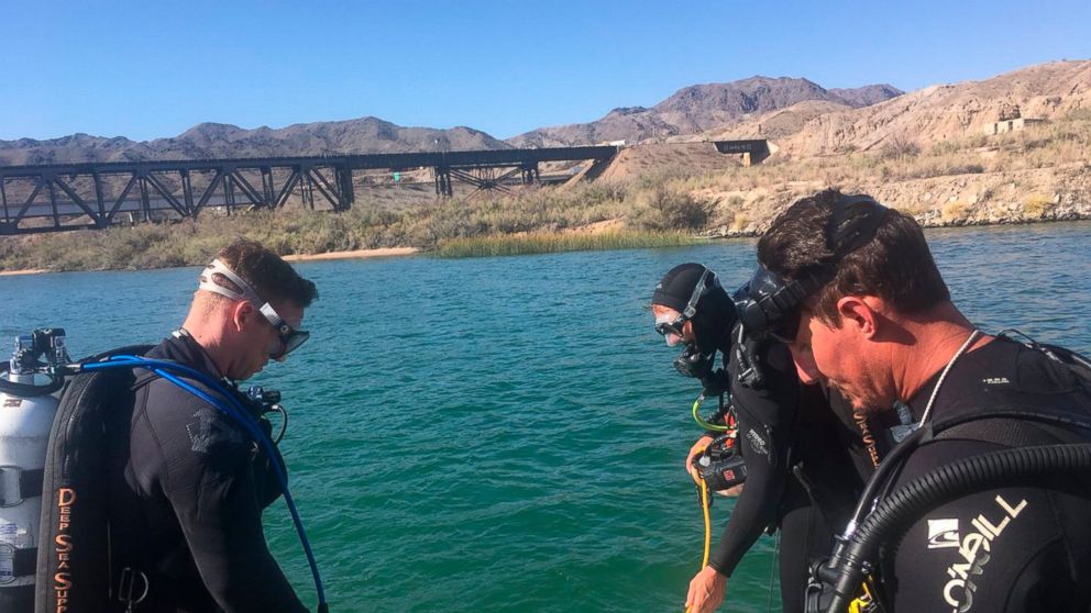 In this photo released by Los Angeles Sheriff Department Special Enforcement Bureau their dive team assists San Bernardino County Sheriffs in the search for three missing persons in the Colorado river Monday, Sept. 3, 2018, near Topock, Ariz.