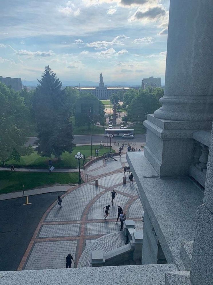 PHOTO: People scramble for cover outside the Colorado State Capitol in Denver on May 28, 2020, after someone fired gunshots in the area during a protest of George Floyd's death. No one was injured.