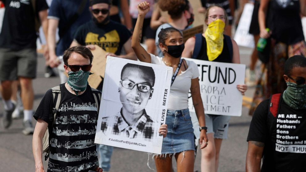 PHOTO: Demonstrators march with placards during a rally in response to the death of Elijah McClain in Aurora, Colo., June, 27, 2020.