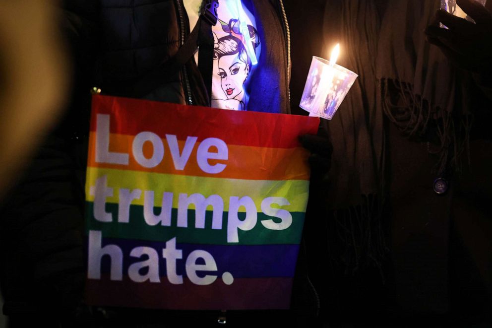 PHOTO: A woman holds a rainbow flag while visiting a makeshift memorial near the Club Q nightclub, Nov. 21, 2022 in Colorado Springs, Colorado.