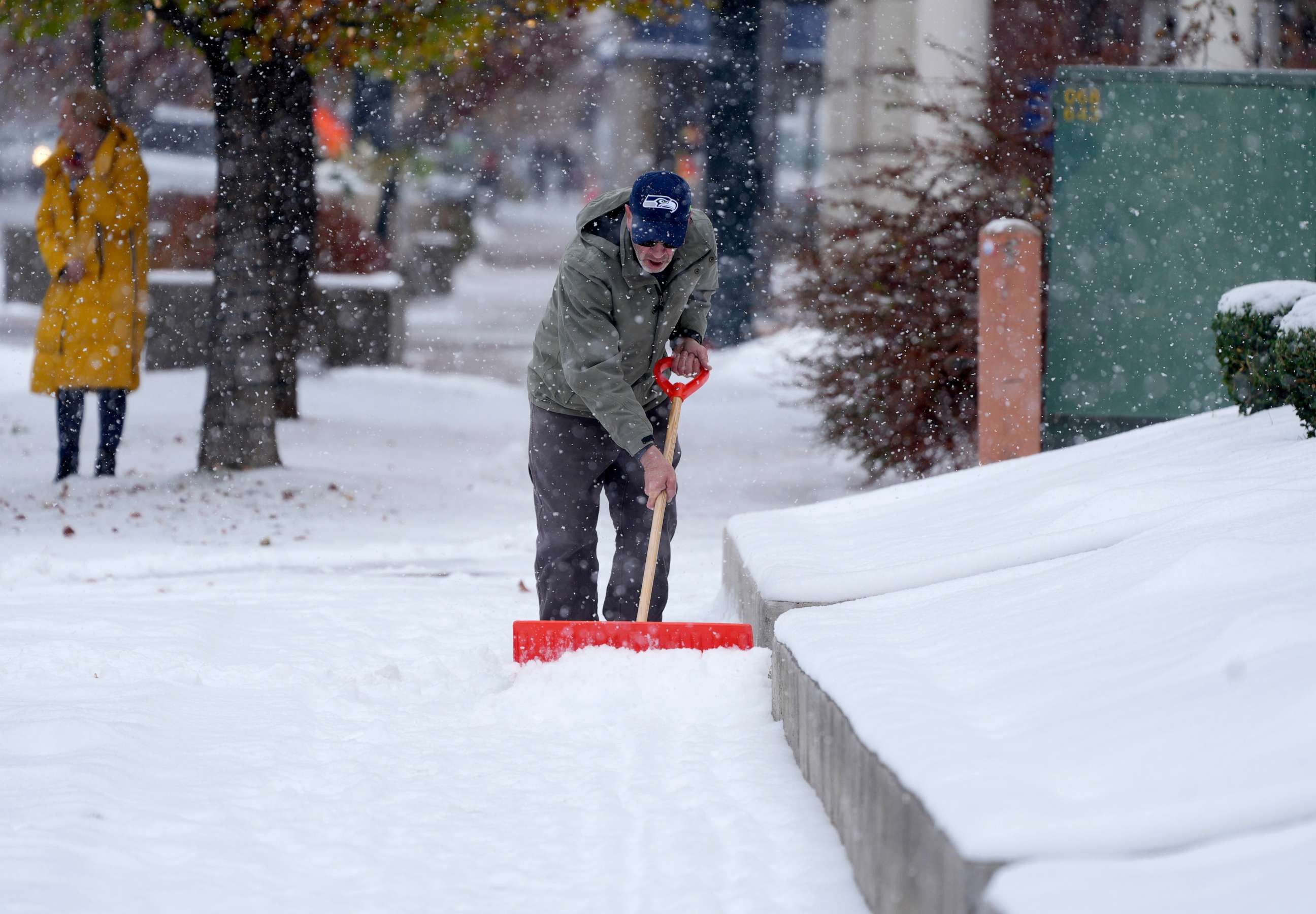 PHOTO: A homeowner clears snow from a walkway after a cold front packing subfreezing temperatures and light snow swept over the area, Nov. 17, 2022, in Denver.