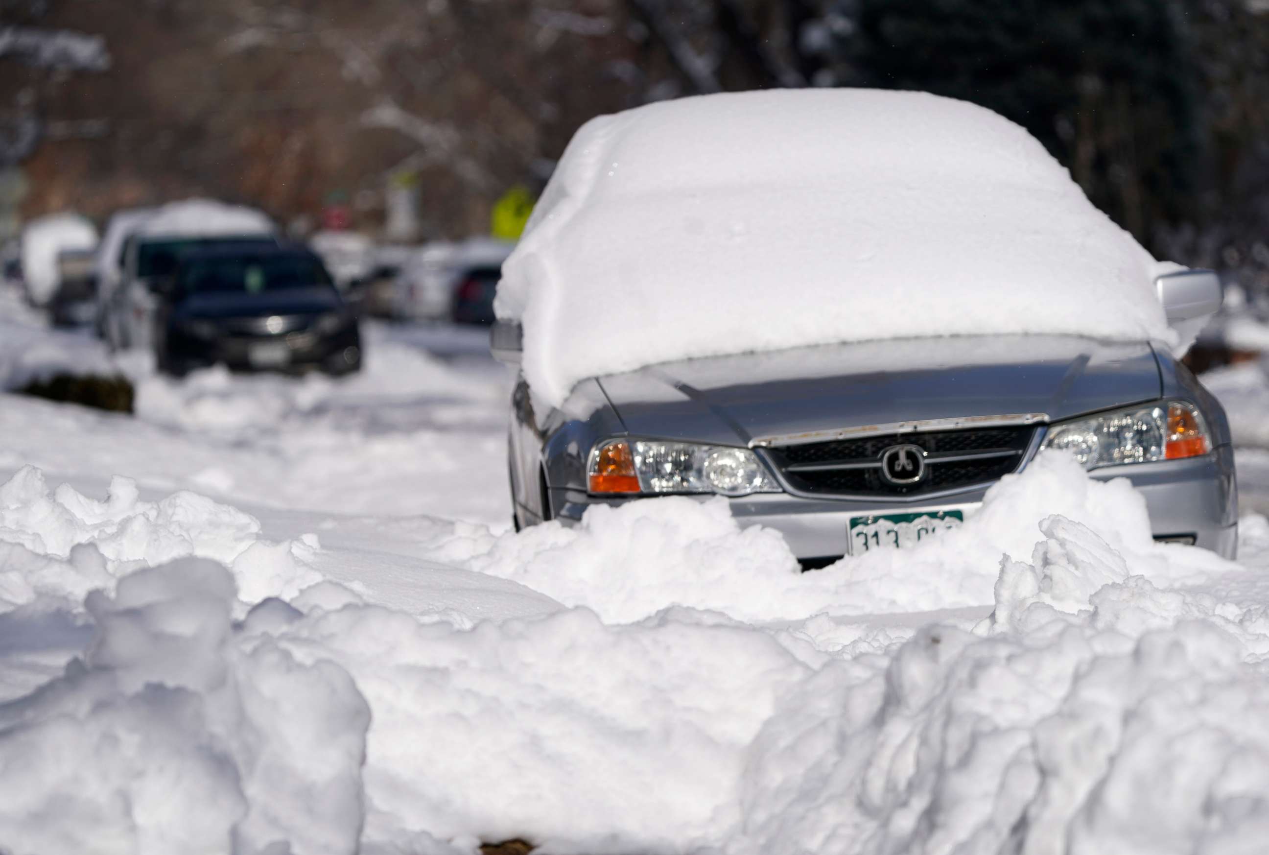 PHOTO: A sedan is buried after more than a foot of snow left by a late winter storm that swept over the region on Feb. 25, 2021, in Denver, Colorado.