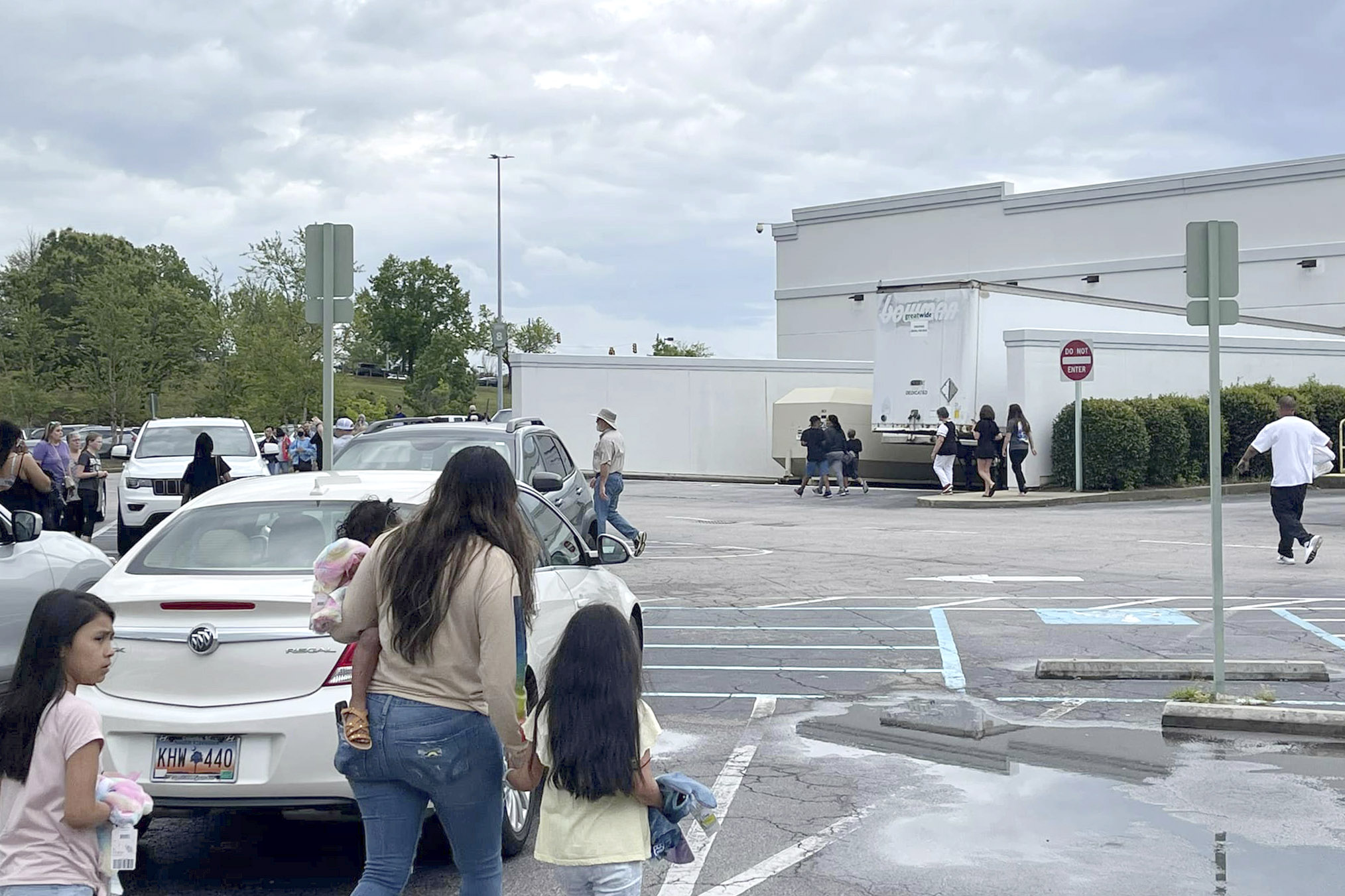 PHOTO: People walk through a parking lot at the Columbiana Centre mall in Columbia, S.C. on April 16, 2022, as police investigate a shooting at the shopping center. 