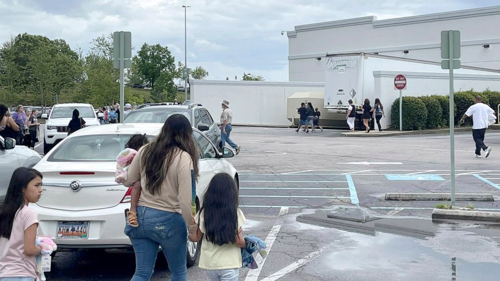 PHOTO: People walk through a parking lot at the Columbiana Centre mall in Columbia, S.C. on April 16, 2022, as police investigate a shooting at the shopping center. 