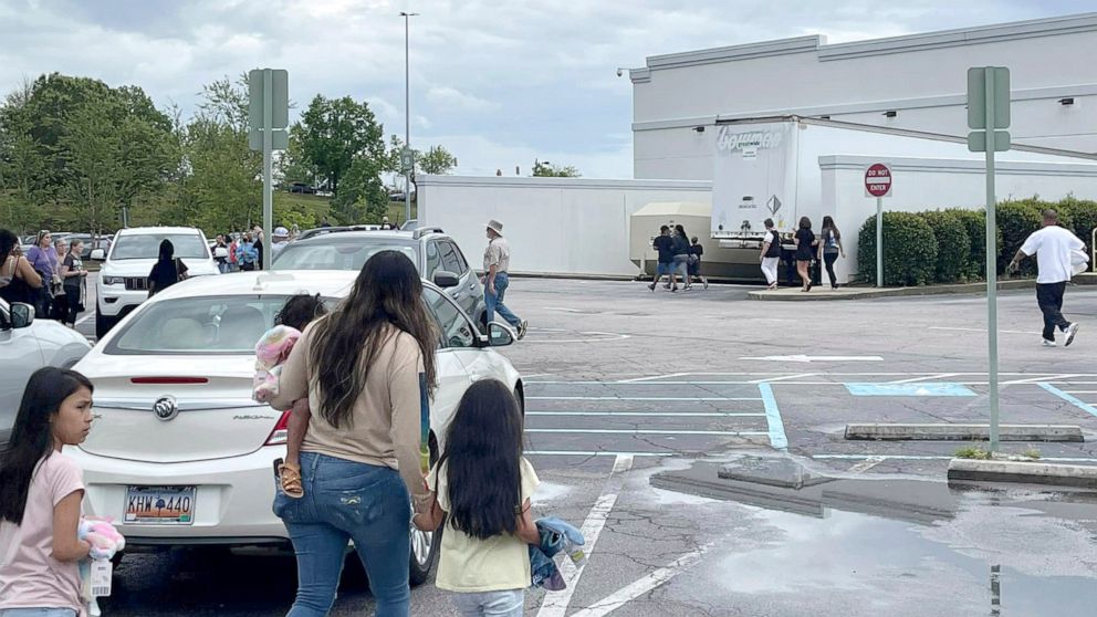 FOTO: La gente camina por un estacionamiento en el centro comercial Columbiana Center en Columbia, Carolina del Sur, el 16 de abril de 2022, mientras la policía investiga un tiroteo en el centro comercial.