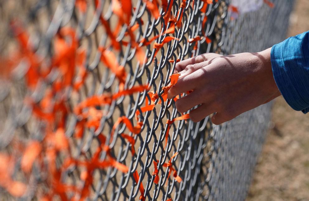 PHOTO: Columbine High School student Andrew Pavicich ties a memorial ribbon on the fence outside the school during a National School Walkout to honor the 17 students and staff members killed at Marjory Stoneman Douglas High School, March 14, 2018. 