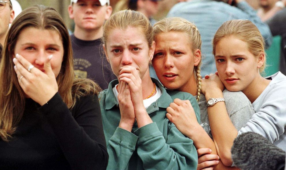 PHOTO: Students from Columbine High School in Littleton, Colo., watch as the last of their fellow students are evacuated from the school building following a mass shooting at the school on April 20, 1999.