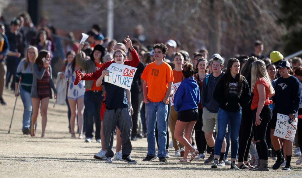 PHOTO: Students carry a placards during a student walkout to protest gun violence on the soccer field behind Columbine High School on March 14, 2018, in Littleton, Colo.