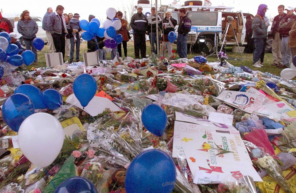 PHOTO: Residents of Littleton, CO stand near a carpet of flowers, mourning the dead at Columbine High School, April 21, 1999. Thirteen fellow students were killed and twenty more were injured in a shooting at the school.