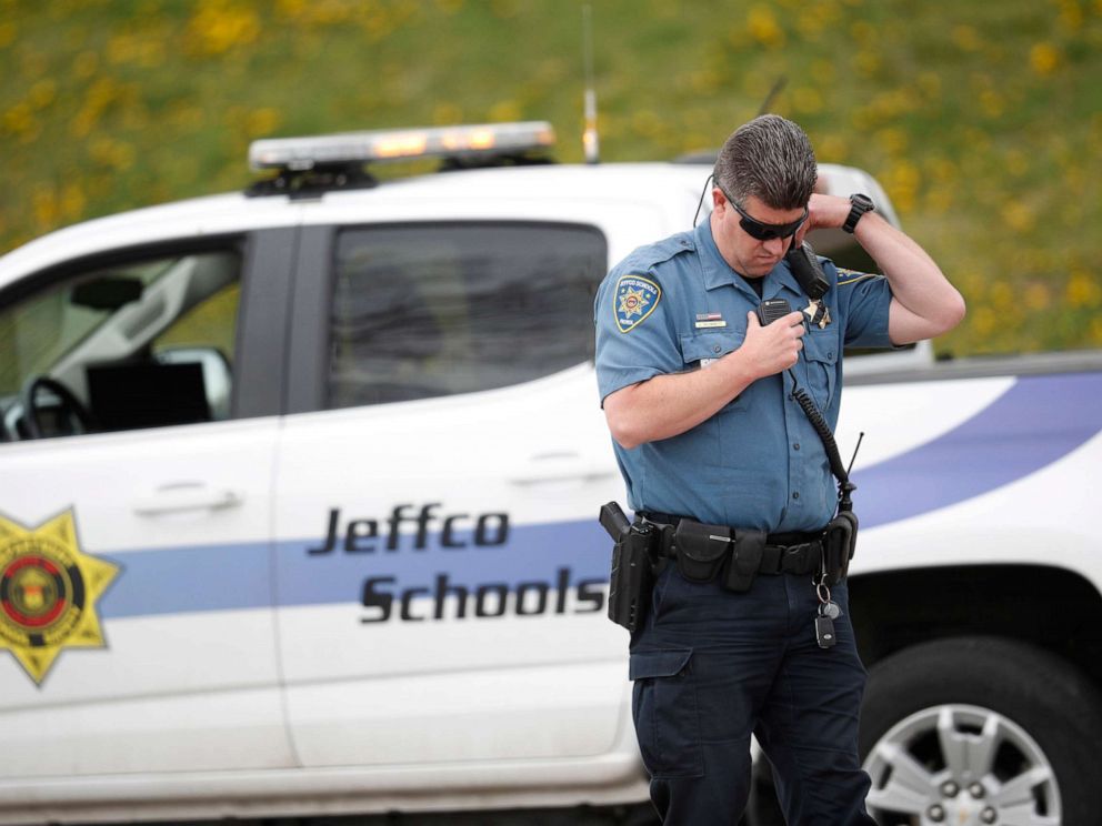 PHOTO: An officer from Jefferson County, Colo., Schools listens on his radio as students leave Columbine High School, April 16, 2019, in Littleton, Colo.