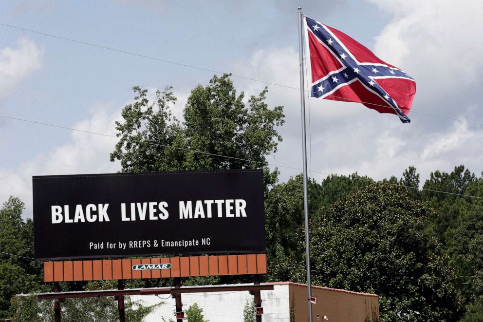 PHOTO: A Black Lives Matter billboard is seen next to a Confederate flag in Pittsboro, N.C., July 16, 2020.