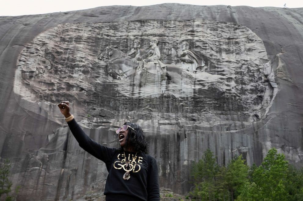 PHOTO: A woman speaks in front of the Confederate Monument carved into granite at Stone Mountain Park in Stone Mountain, Georgia, June 16, 2020.