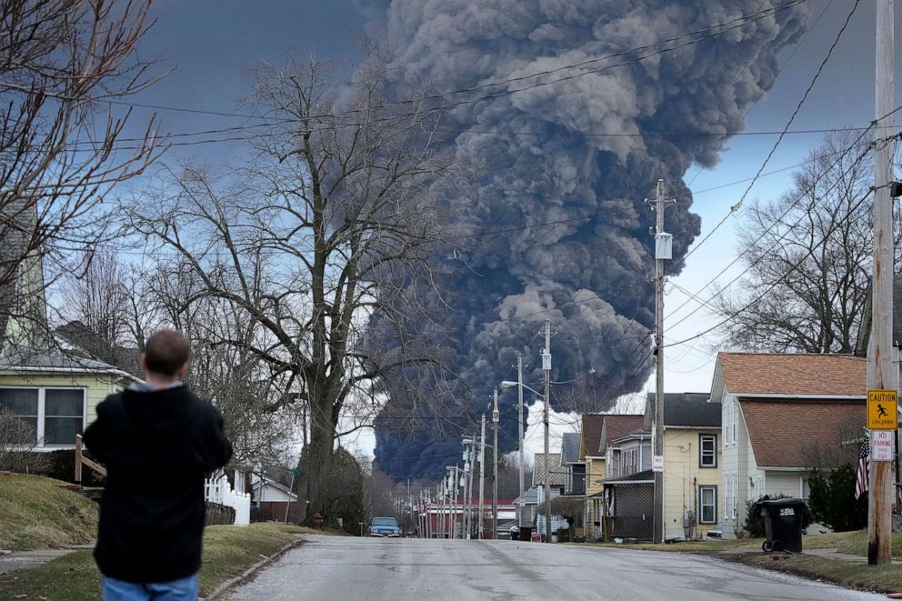 PHOTO: A man takes photos as a black plume rises over East Palestine, Ohio, during a controlled detonation of a portion of the derailed Norfolk Southern train, Feb. 6, 2023.