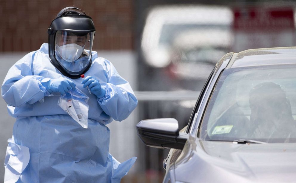 PHOTO: A member of the medical personnel places a Covid-19 test sample in a plastic bag, at a pop up testing site in Boston on June 10, 2020.