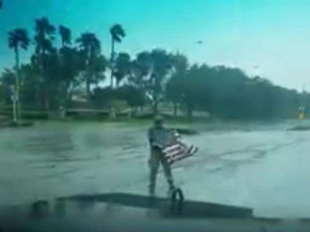 PHOTO: First responder Joseph Schiavo picks up a fallen flag while patrolling in Coral Springs, Florida, after Hurricane Irma hit the area, Sept. 10, 2017.