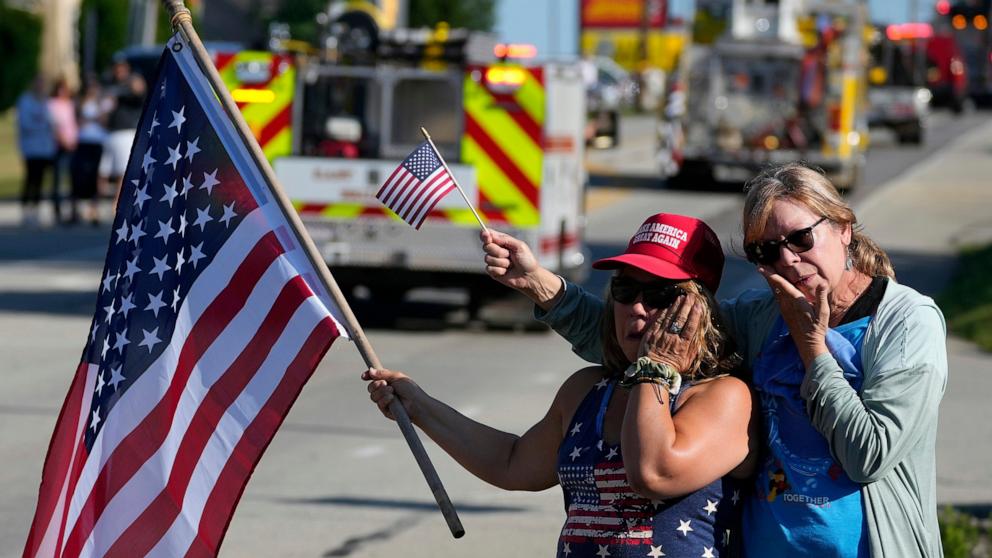 PHOTO: People react as the funeral procession for Corey Comperatore passes by, on July 19, 2024, in Sarver, Pa.