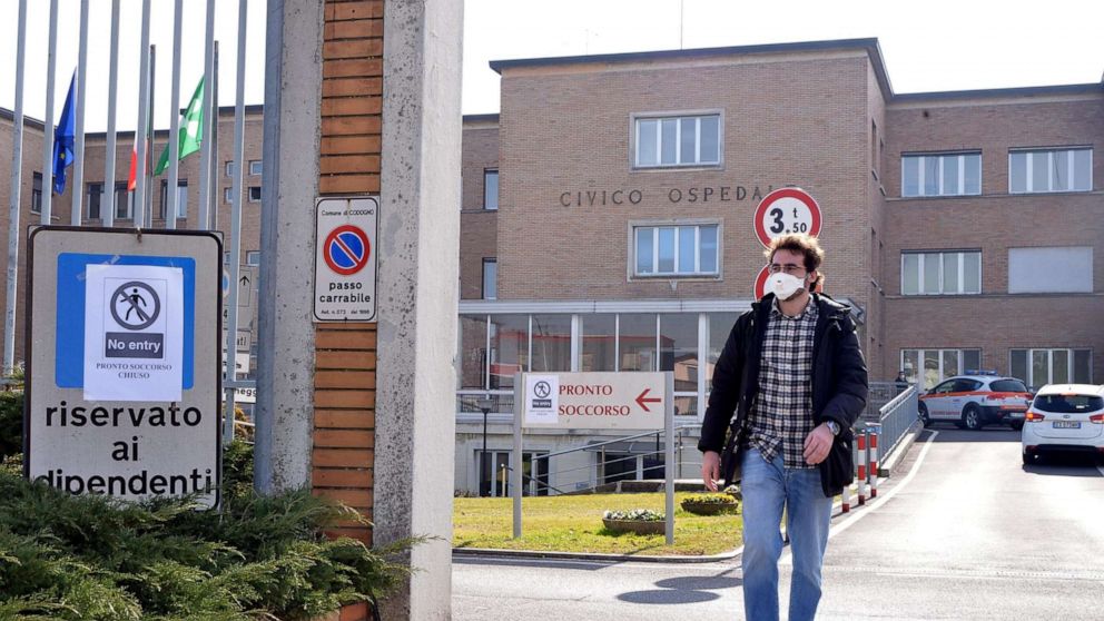 PHOTO: A person wearing a face mask walks out of an entrance gate to the Codogno Civic Hospital, where the emergency room was closed as a precautionary measure, in Codogno, near Lodi, northern Italy on Feb. 21 2020. 