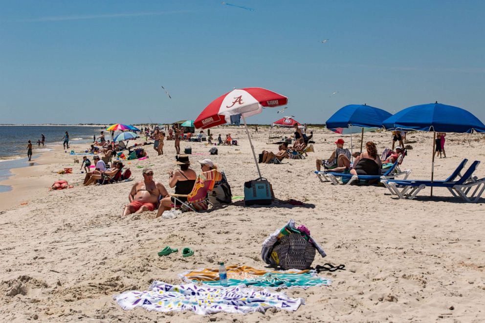 PHOTO: People sit on the sand at a public beach in Dauphin Island, Ala., May 1, 2020.