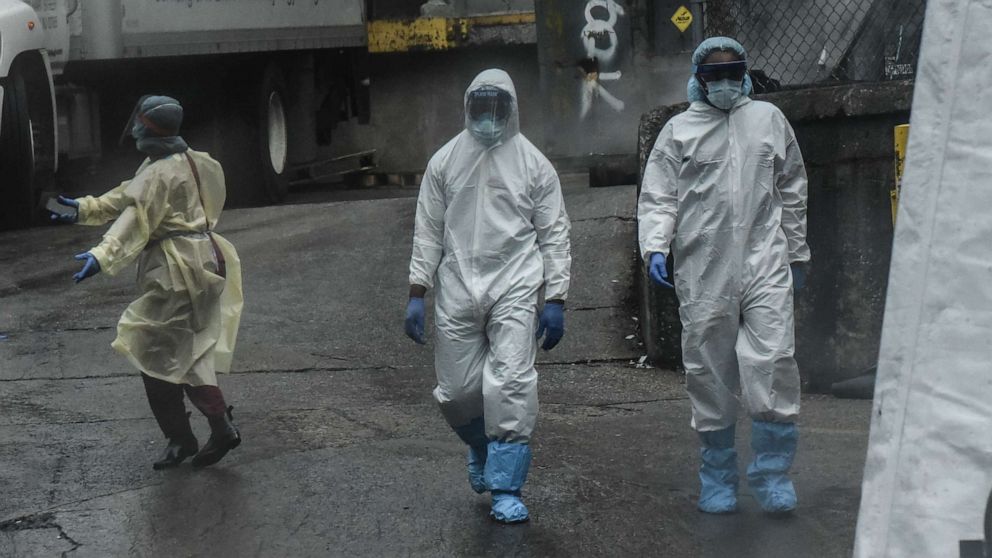 PHOTO: Medical workers approach a refrigerator truck being used as a morgue outside of Brooklyn Hospital Center amid the coronavirus pandemic on April 3, 2020, in New York.