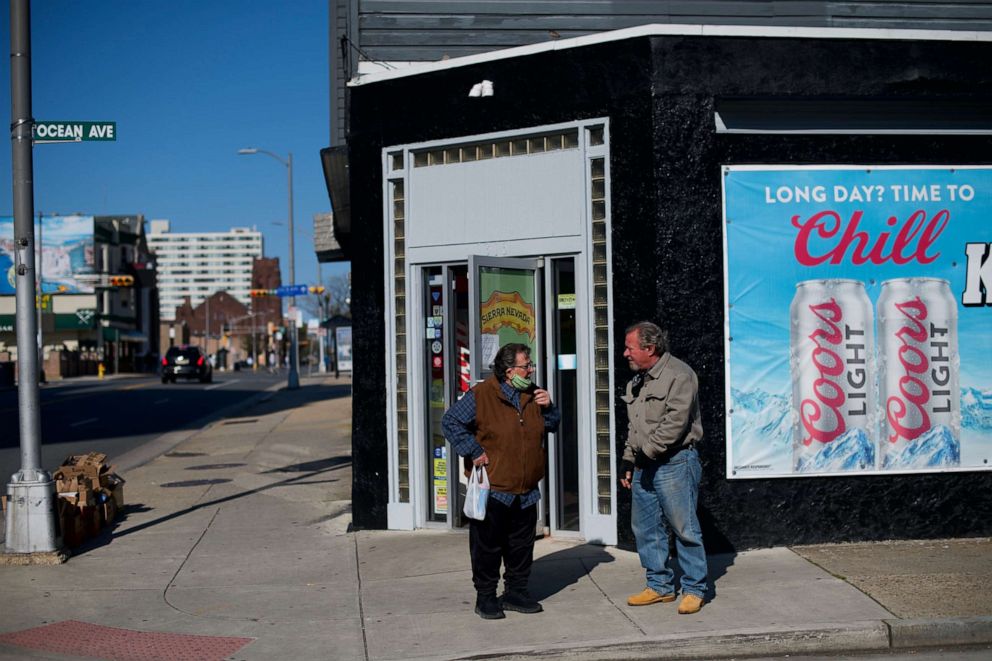 PHOTO: A man and woman converse outside a beer store during the coronavirus pandemic on May 7, 2020, in Atlantic City, N.J.