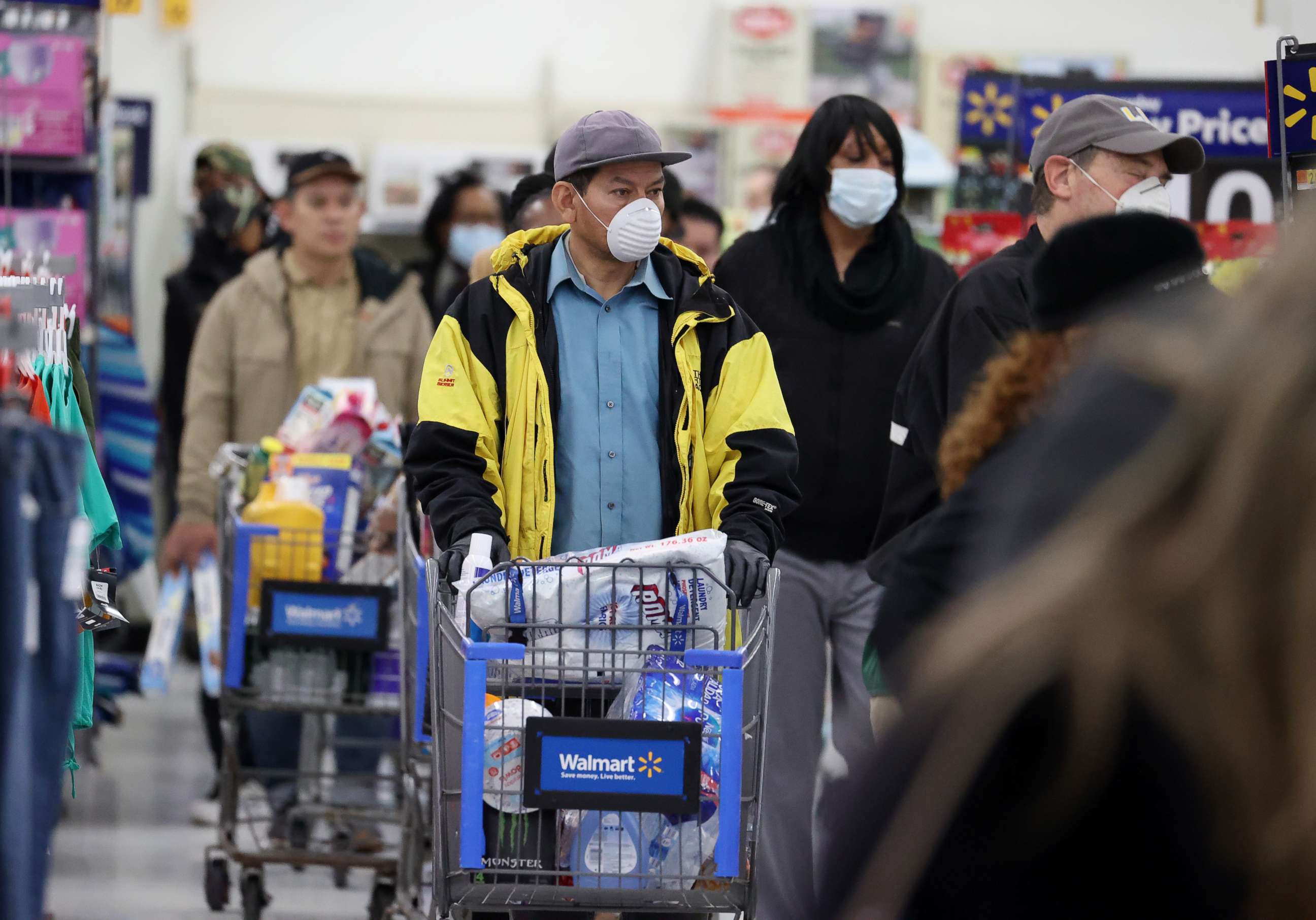 PHOTO: People wearing masks and gloves wait to checkout at Walmart on April 03, 2020, in Uniondale, New York.
