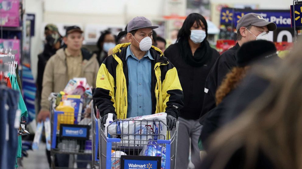 PHOTO: People wearing masks and gloves wait to checkout at Walmart on April 03, 2020, in Uniondale, New York.