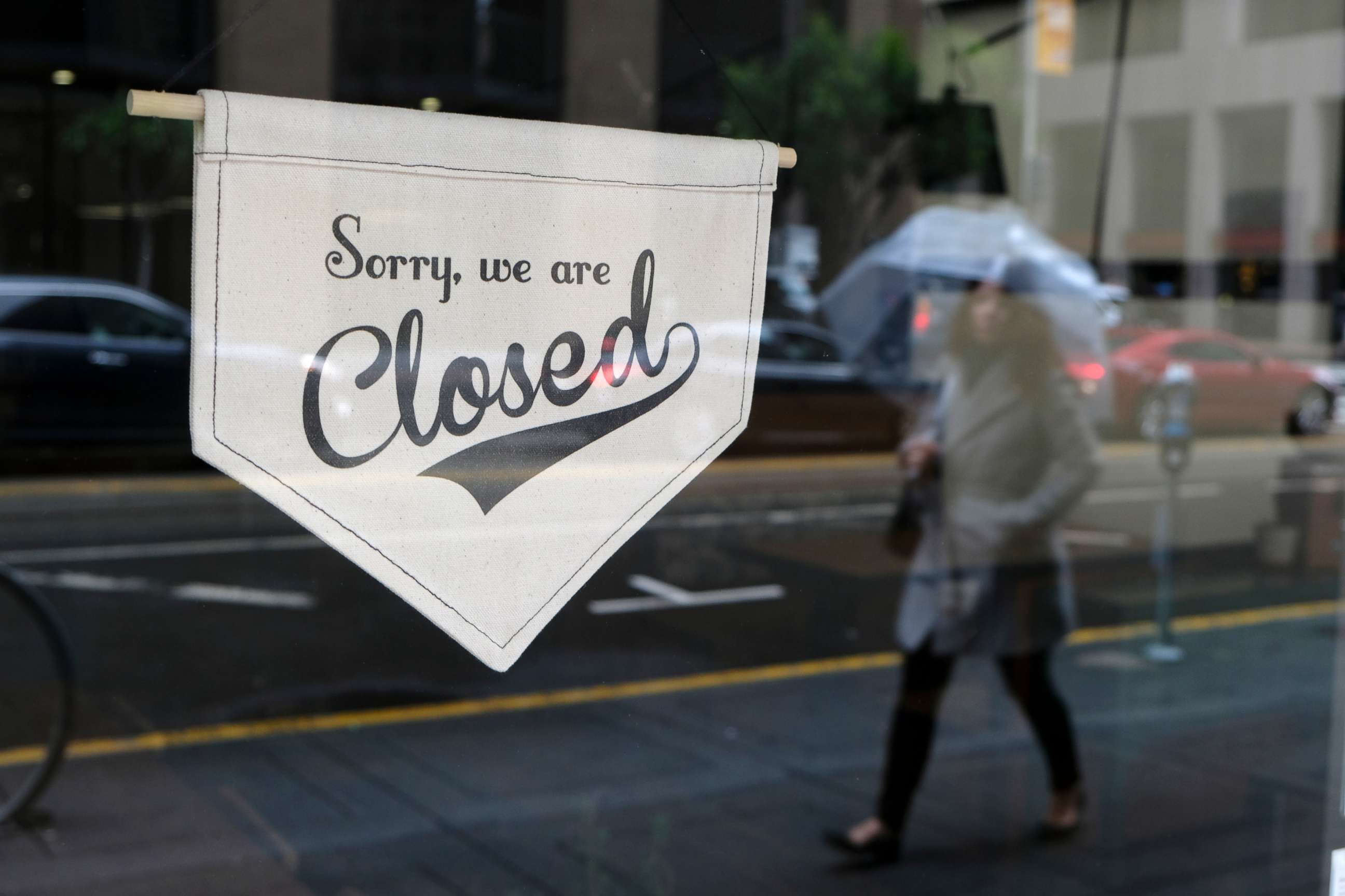 PHOTO: A woman walks along through the Financial District past the closed Homage Ltd. restaurant which is normally open for breakfast and lunch, March 16, 2020, in San Francisco. 