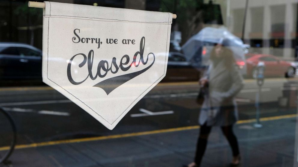 PHOTO: A woman walks along through the Financial District past the closed Homage Ltd. restaurant which is normally open for breakfast and lunch, March 16, 2020, in San Francisco. 