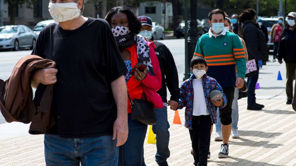 PHOTO: People queue to get free masks distributed by Urban Park Rangers at Grand Army Plaza, during the outbreak of the coronavirus disease (COVID-19) in Brooklyn, New York, May 3, 2020. 