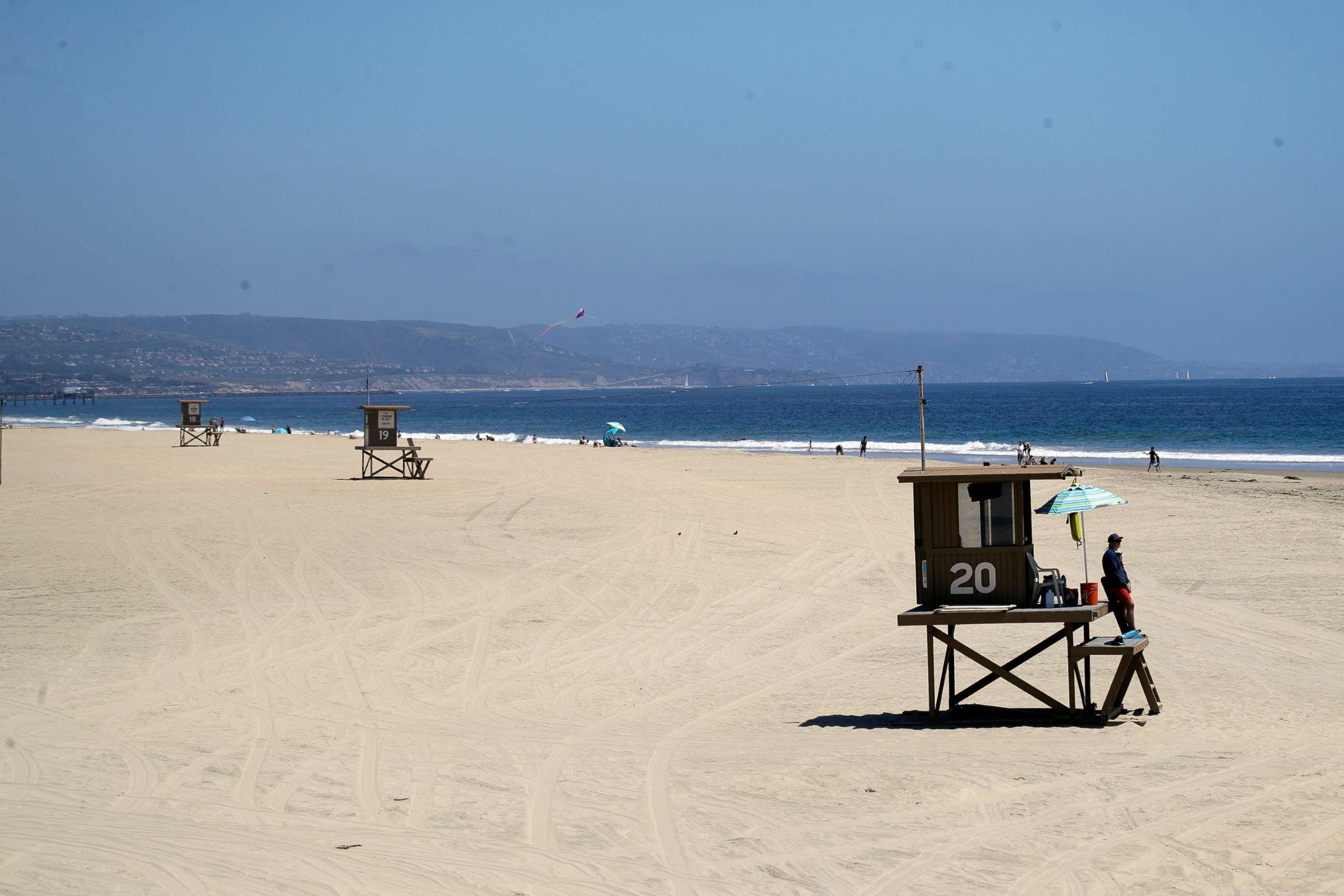 PHOTO: Lifeguards keep a lookout on a mostly empty beach, May 3, 2020, in Newport Beach, Calif. 